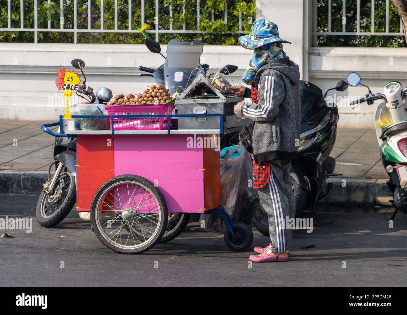 Une femme vend de la viande grillée dans une cabine mobile située dans une rue du centre-ville Banque D'Images