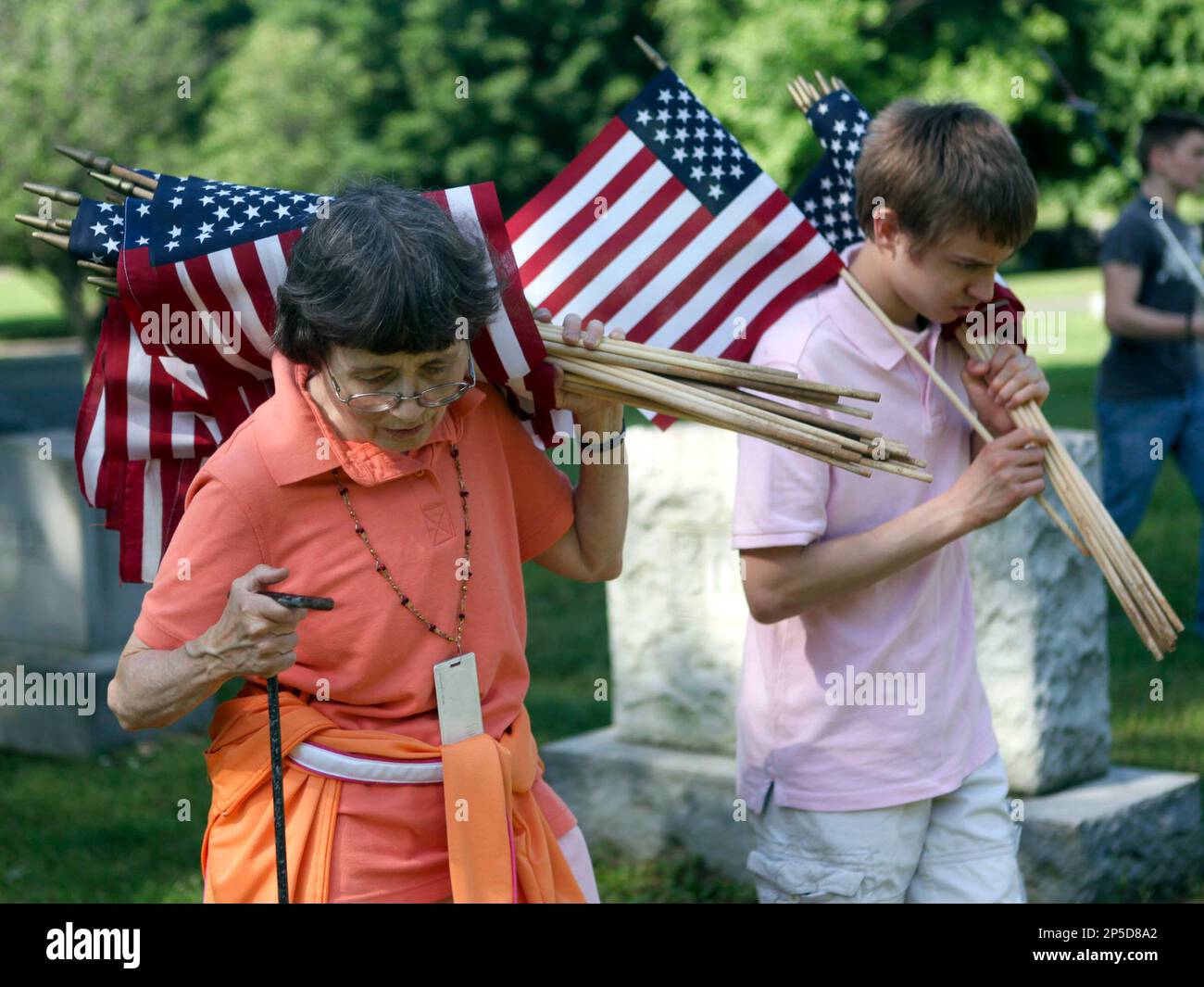 Ricki Fowler, a para professional. and ROTC member Lucas Ellis, both from Patrick Henry High School, carry flags to plant amongst the graves of veterans in honor of Memorial Day at Evergreen Burial Park on Wednesday, May 22, 2013, in Roanoke, Va. (AP Photo/The Roanoke Times, Stephanie Klein-Davis) LOCAL TV OUT; SALEM TIMES REGISTER OUT; FINCASTLE HERALD OUT; CHRISTIANBURG NEWS MESSENGER OUT; RADFORD NEWS JOURNAL OUT; ROANOKE STAR SENTINEL OUT Banque D'Images
