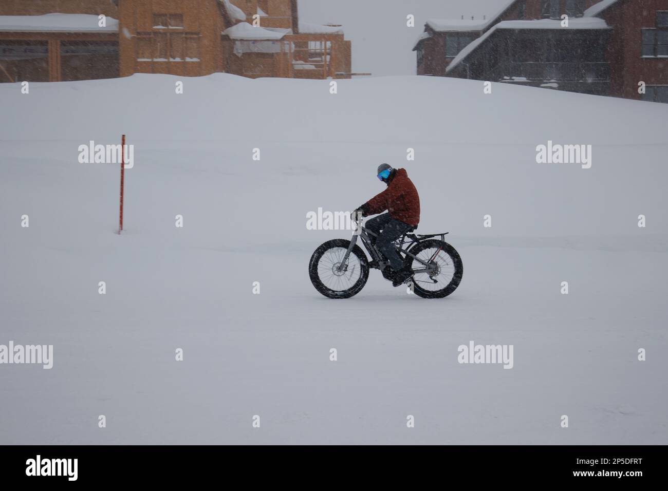 Mammoth Lakes, Californie. 27 février 2023. Un cycliste sur une pédale électrique sur une route enneigée pendant un blizzard d'hiver. Banque D'Images