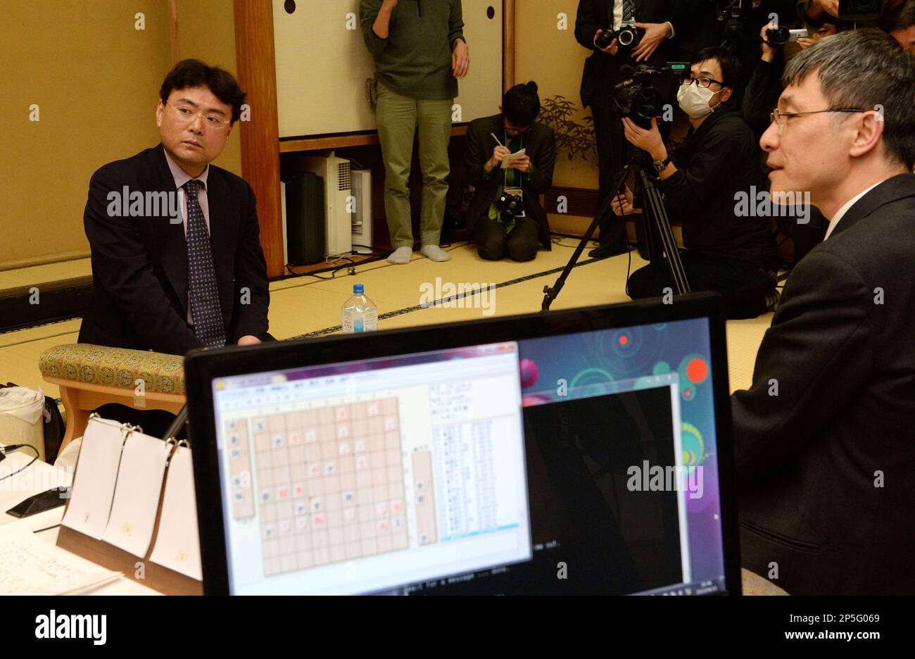 Professional shogi (Japanese chess) player Yasuaki Tsukada (L) and Hikdeki Ito, inventor of Puella Alpha, a computershogi-program, hold their fourth game of the Den Ou Sen at Japan Shogi Association in Shibuya Ward, Tokyo on April 13, 2013. Former professional shogi player was defeated by the computer last year and human active professional revenged the game. The match between human and computer ended with a draw. ( The Yomiuri Shimbun via AP Images ) Banque D'Images