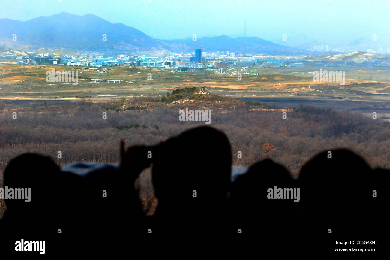Visitors look over the North-South Korea industrial complex in Kaesong, North Korea, through binoculars at Dora Observation Post in the demilitarized zone (DMZ) near the border village of Panmunjom, in Paju, South Korea, Tuesday, April 9, 2013. The massive industrial park the rival Koreas have jointly run for nearly decade was a virtual ghost town Tuesday, its South Korean managers left to wander past shutdown assembly lines or stuff their cars to the brim with whatever goods would fit before heading south for the Demilitarized Zone that divides the nations. (AP Photo/Won Dae-hyun) KOREA OUT Banque D'Images