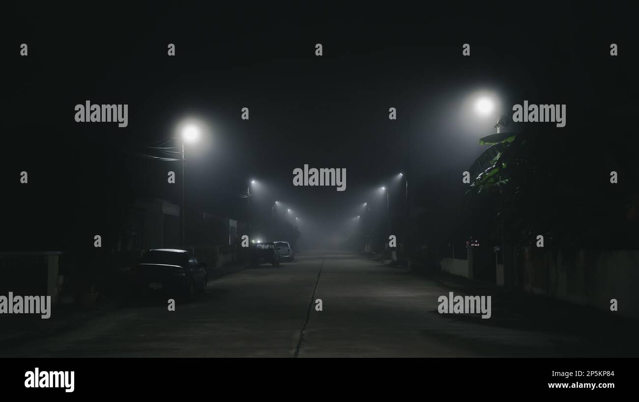 Scène de nuit de rue avec fond de brouillard dans le village et concept de ville silencieuse Banque D'Images