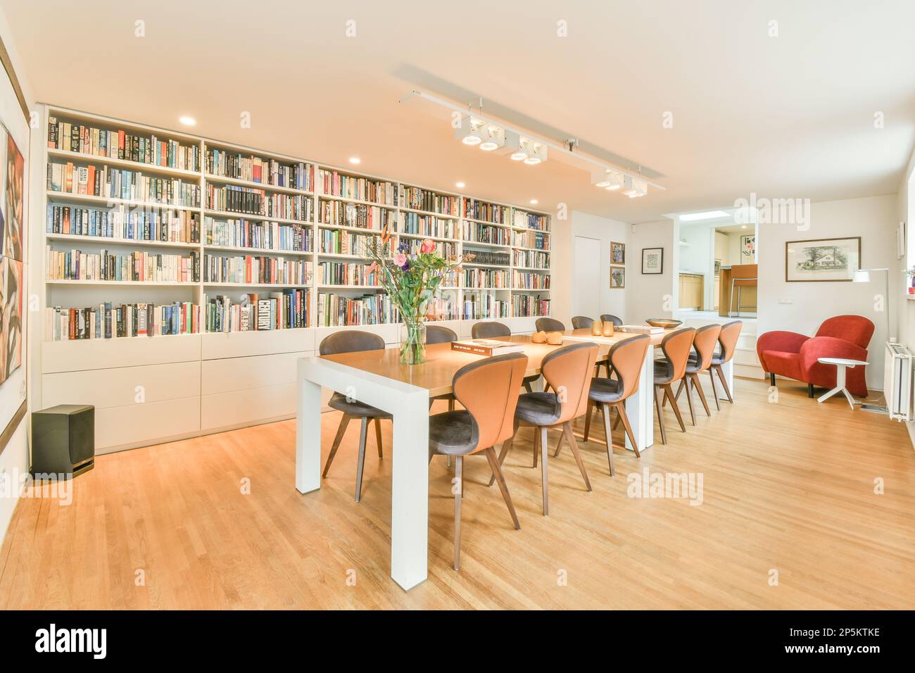 un salon avec de nombreux livres sur les étagères et des chaises devant les bibliothèques qui sont pleines de livres Banque D'Images