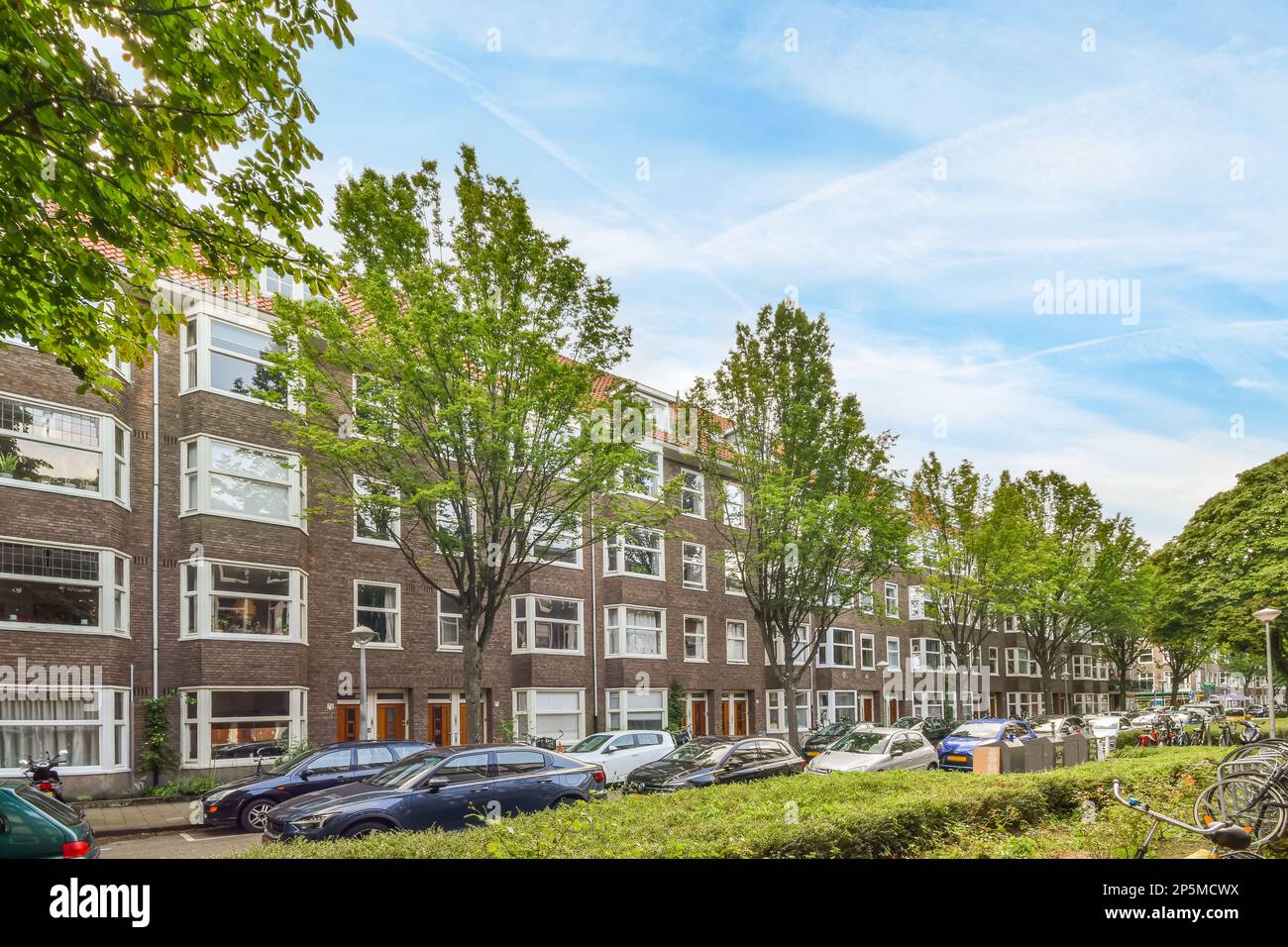Amsterdam, pays-Bas - 10 avril 2021 : une rue urbaine avec des voitures garées et des vélos à amsterdam, aux pays-bas, sur une photo lumineuse et ensoleillée par le shutterstocker Banque D'Images