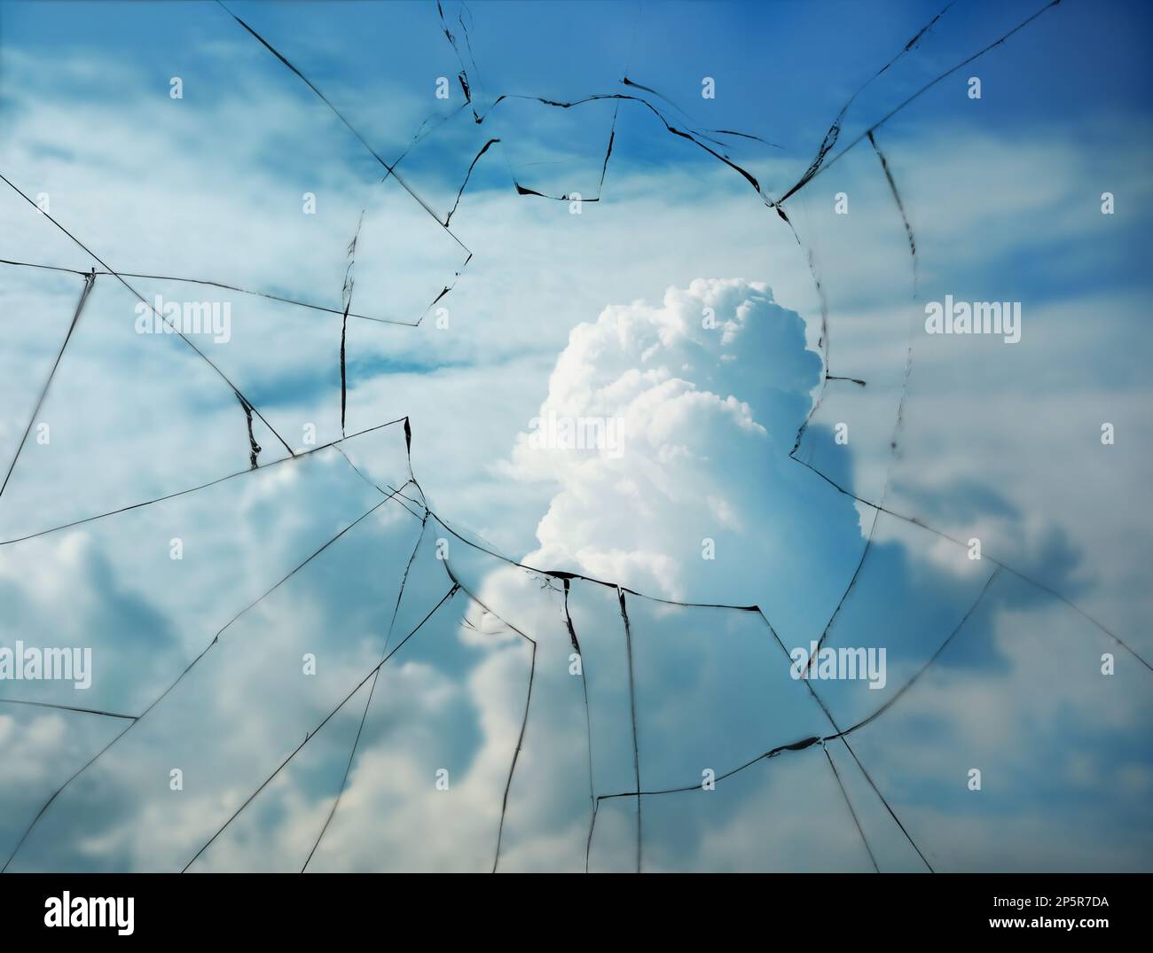 Vue par une fenêtre brisée dans un ciel nuageux Banque D'Images