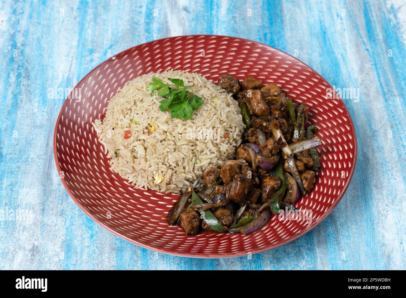 Poulet au piment sec avec un bol de riz frit sur fond texturé Banque D'Images