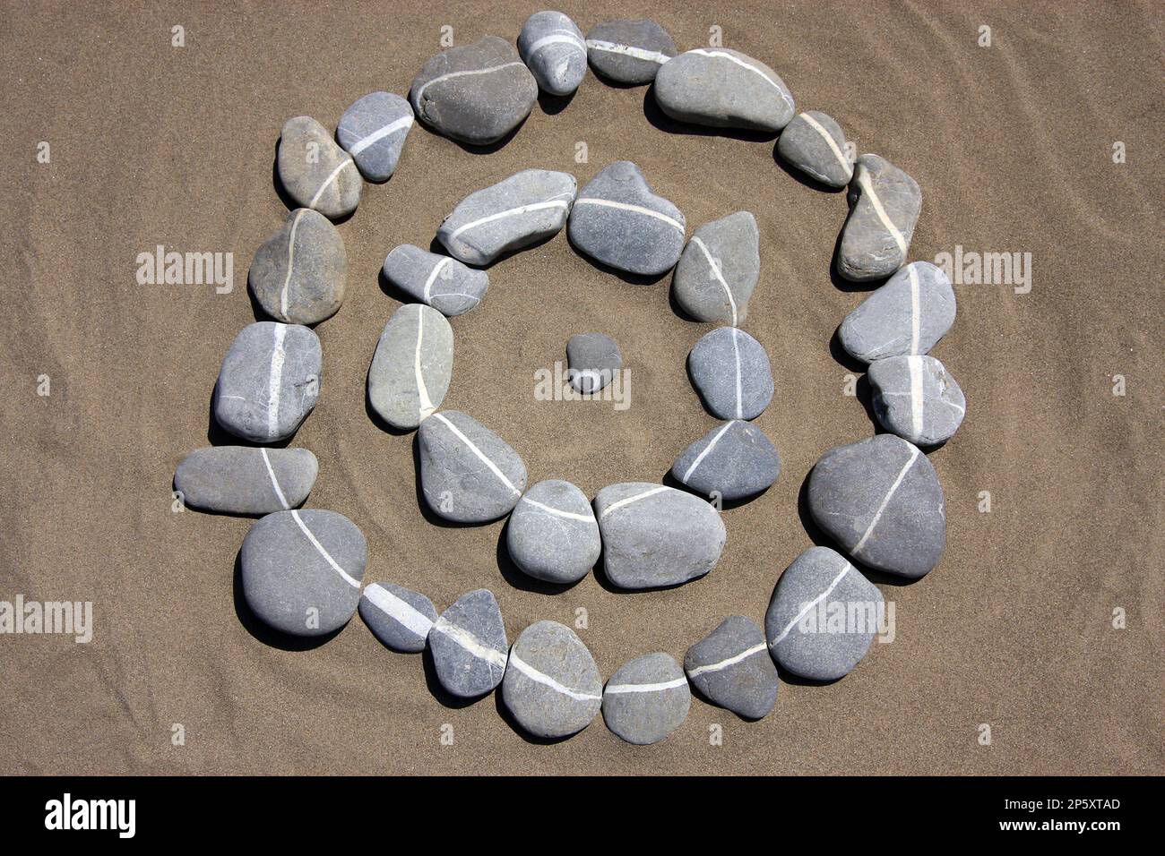 cercles de pierre sur le sable en pierres à rayures blanches Banque D'Images