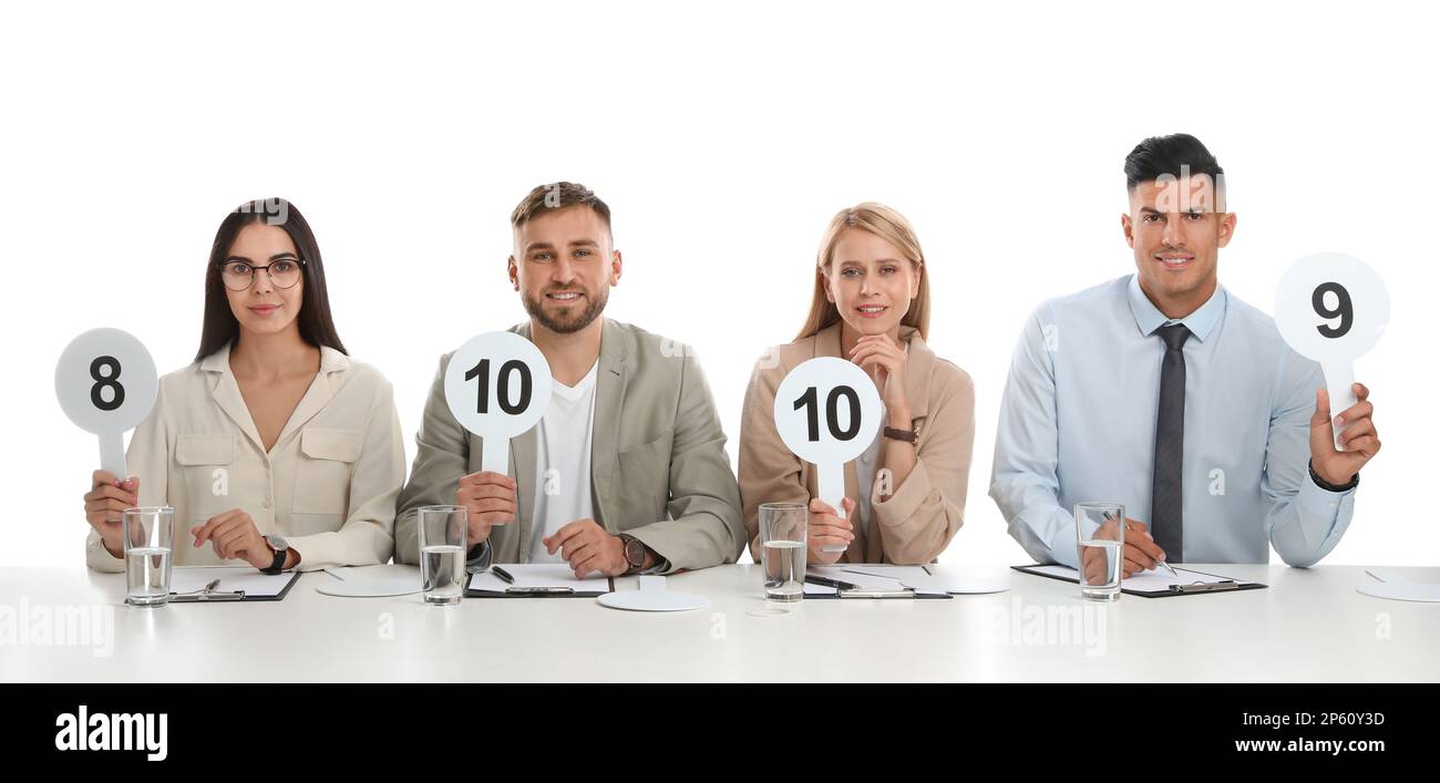 Panel de juges ayant différents signes de score à la table sur fond blanc Banque D'Images