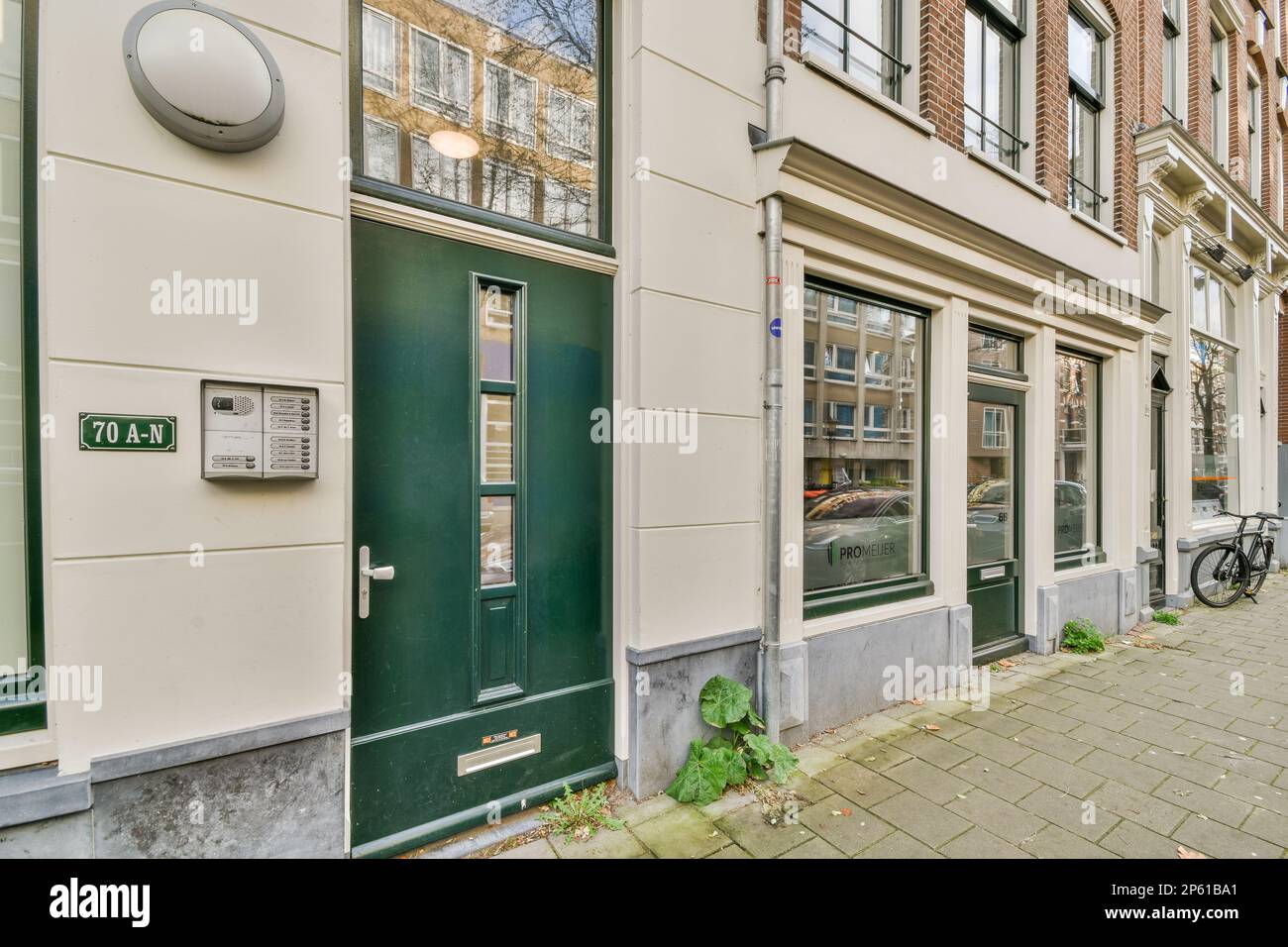 Amsterdam, pays-Bas - 10 avril 2021 : une rue avec des bâtiments en arrière-plan et un vélo stationné sur le trottoir à côté de la porte du bâtiment Banque D'Images