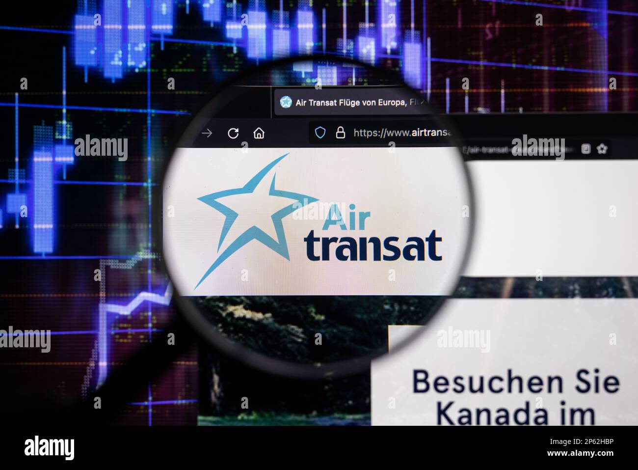 Le logo de la compagnie Air transat sur un site Web présentant des développements flous du marché boursier en arrière-plan, vu sur un écran d'ordinateur à travers une loupe Banque D'Images