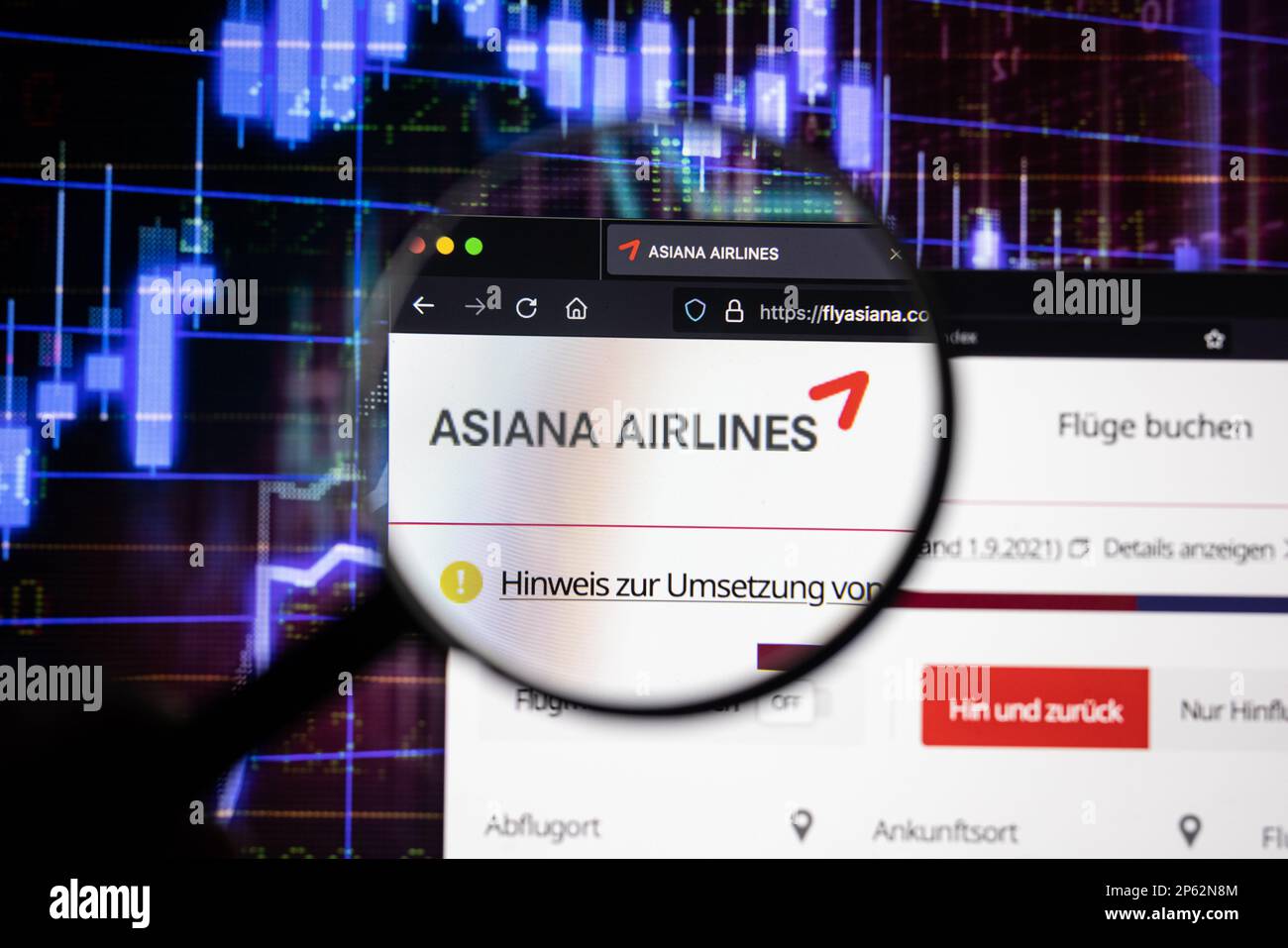 Le logo de la société Asiana Airlines sur un site Web présentant des développements flous du marché boursier en arrière-plan, vu sur un écran à travers une loupe Banque D'Images