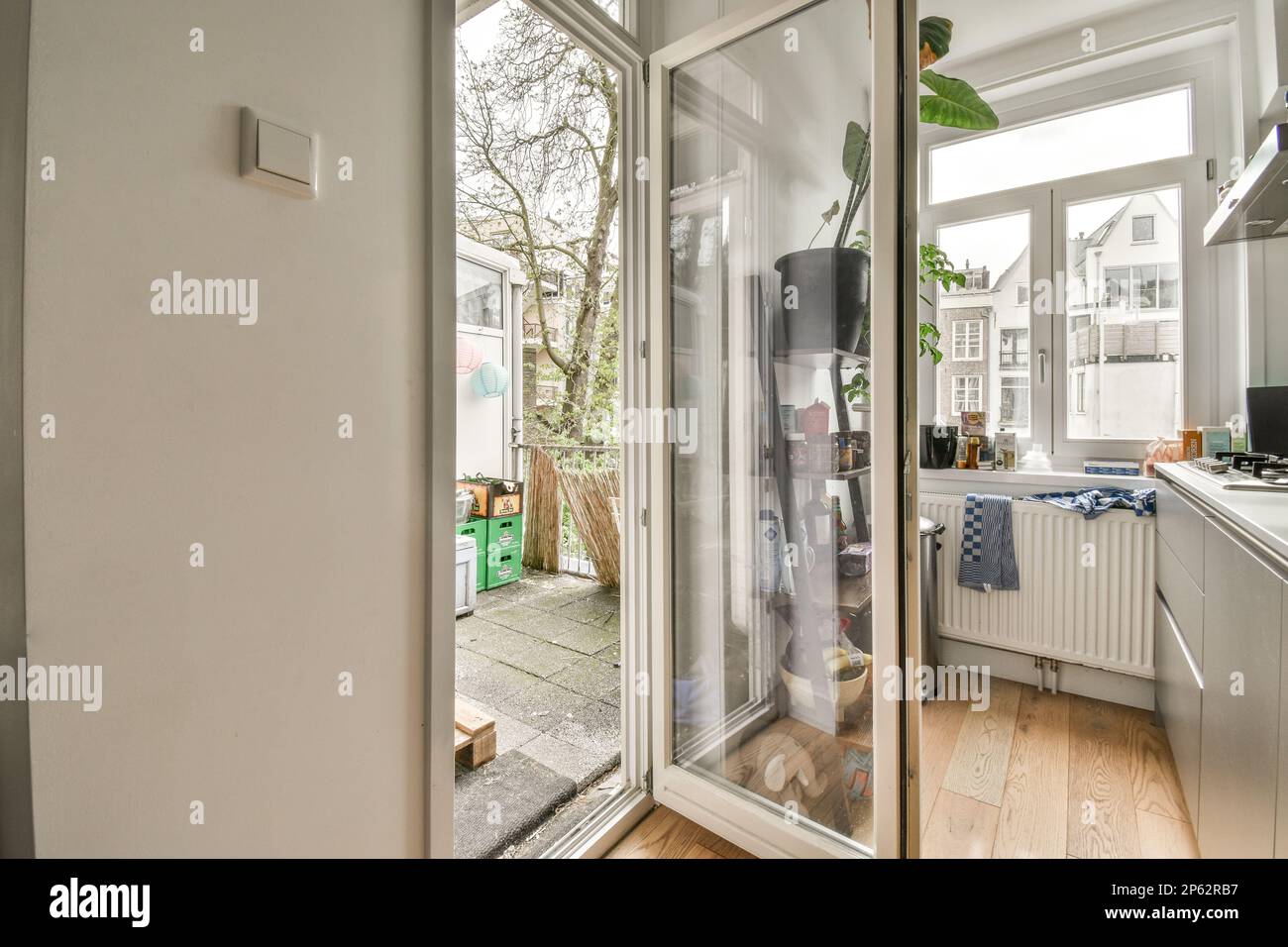 l'intérieur d'une maison avec parquet et porte vitrée coulissante menant à une cuisine extérieure à l'extérieur Banque D'Images