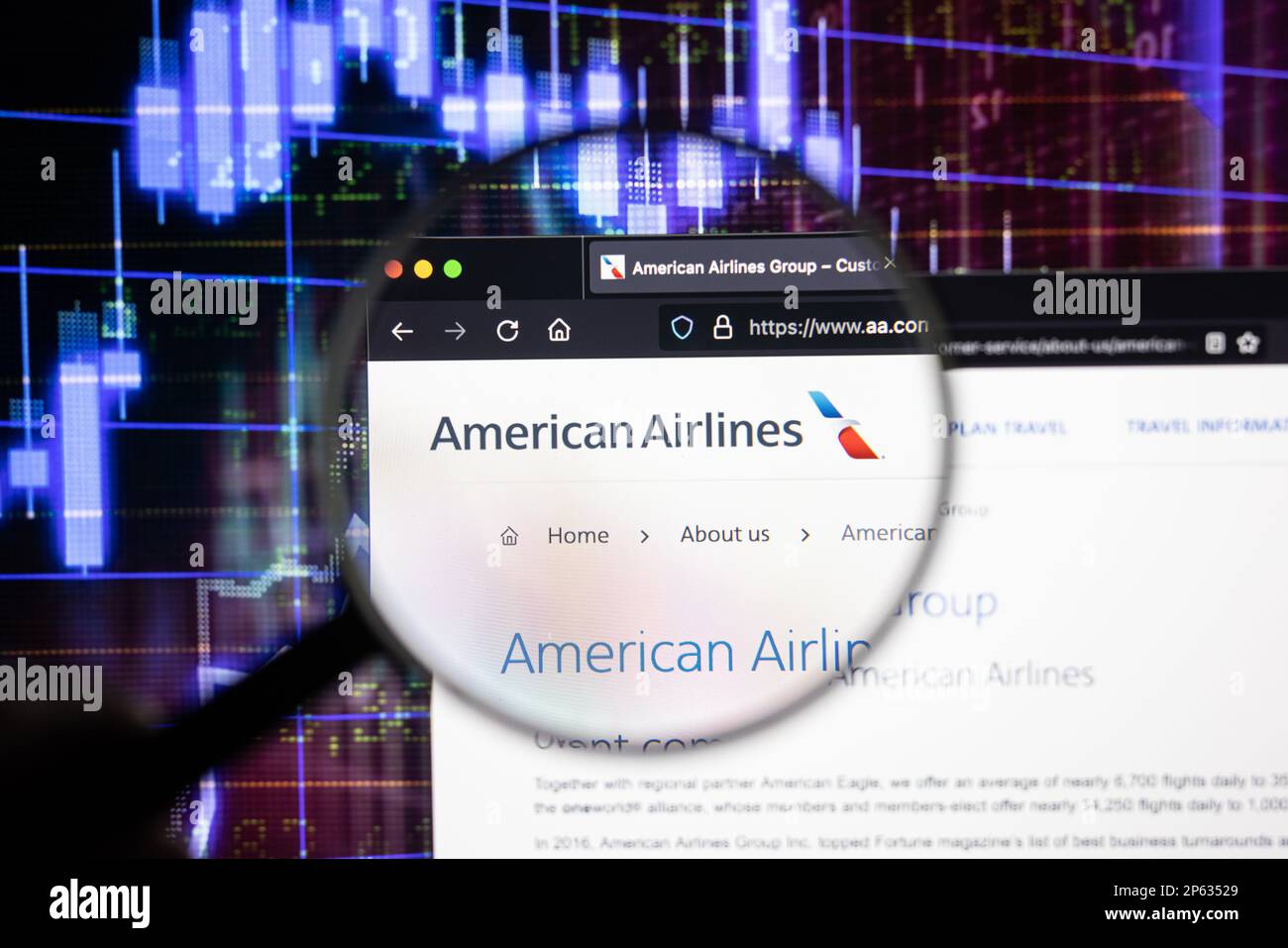 Logo de la société American Airlines sur un site Web présentant des développements flous sur le marché boursier en arrière-plan, vu sur un écran à travers une loupe Banque D'Images
