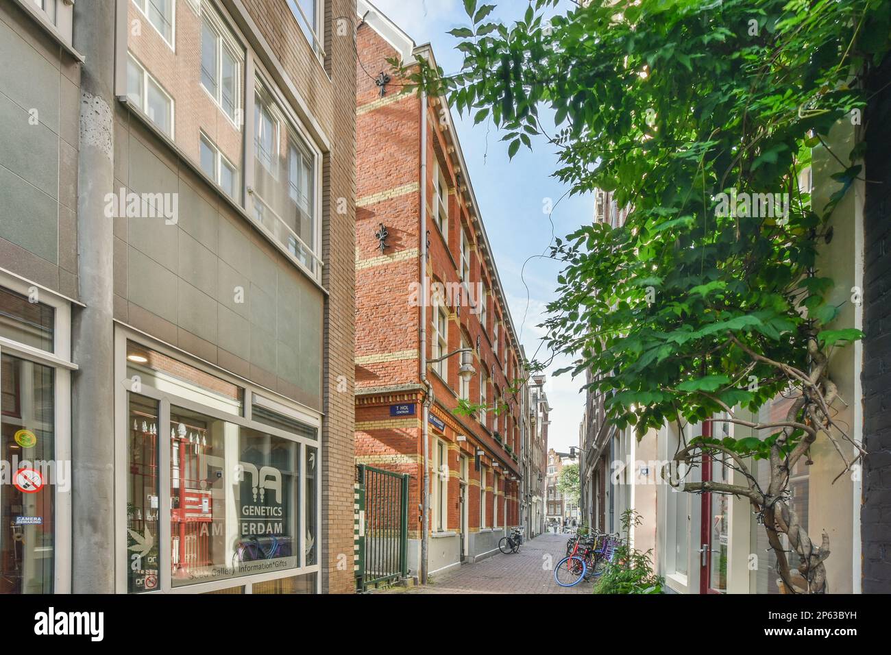 Amsterdam, pays-Bas - 10 avril, 2021: Une rue de la ville avec des bâtiments en arrière-plan et des gens qui marchent dans les allées de chaque côté, il ya un panneau qui dit Banque D'Images