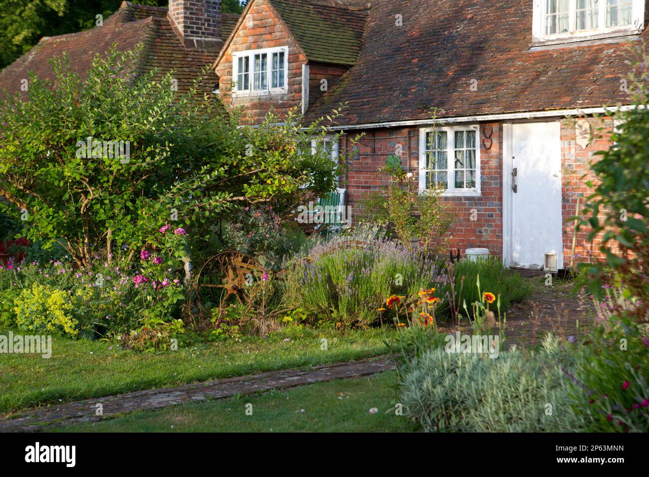 Cottage en brique rouge avec jardin rustique en fonte Banque D'Images