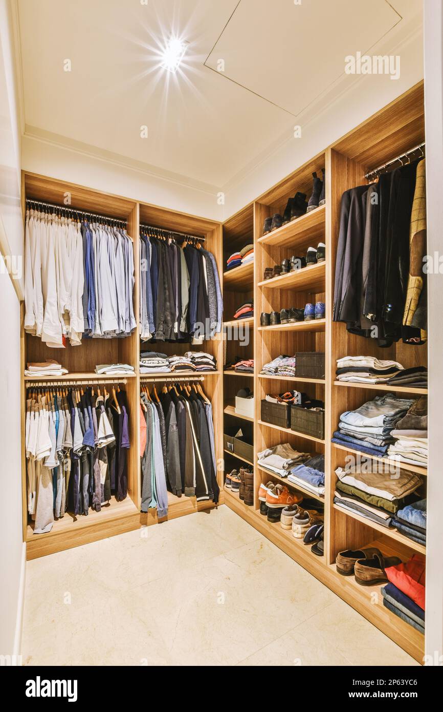 l'intérieur d'une promenade - dans le placard avec des vêtements et des chaussures accrochés sur des étagères en bois, montrant comment il est organisé Banque D'Images