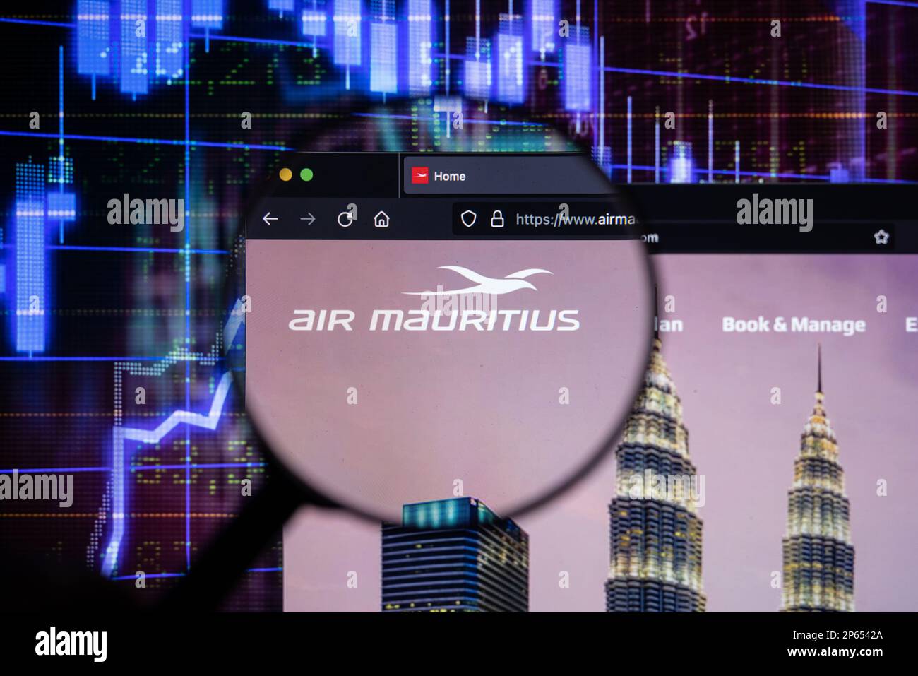 Le logo de la compagnie d'Air Mauritius sur un site Web avec des développements flous du marché boursier en arrière-plan, vu sur un écran d'ordinateur à travers une loupe Banque D'Images