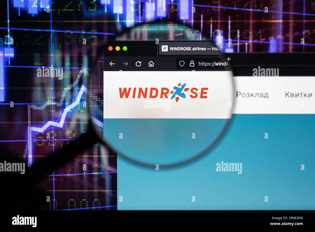 Logo de la compagnie aérienne de Windrose sur un site Web avec des développements flous du marché boursier en arrière-plan, vu sur un écran à travers une loupe Banque D'Images