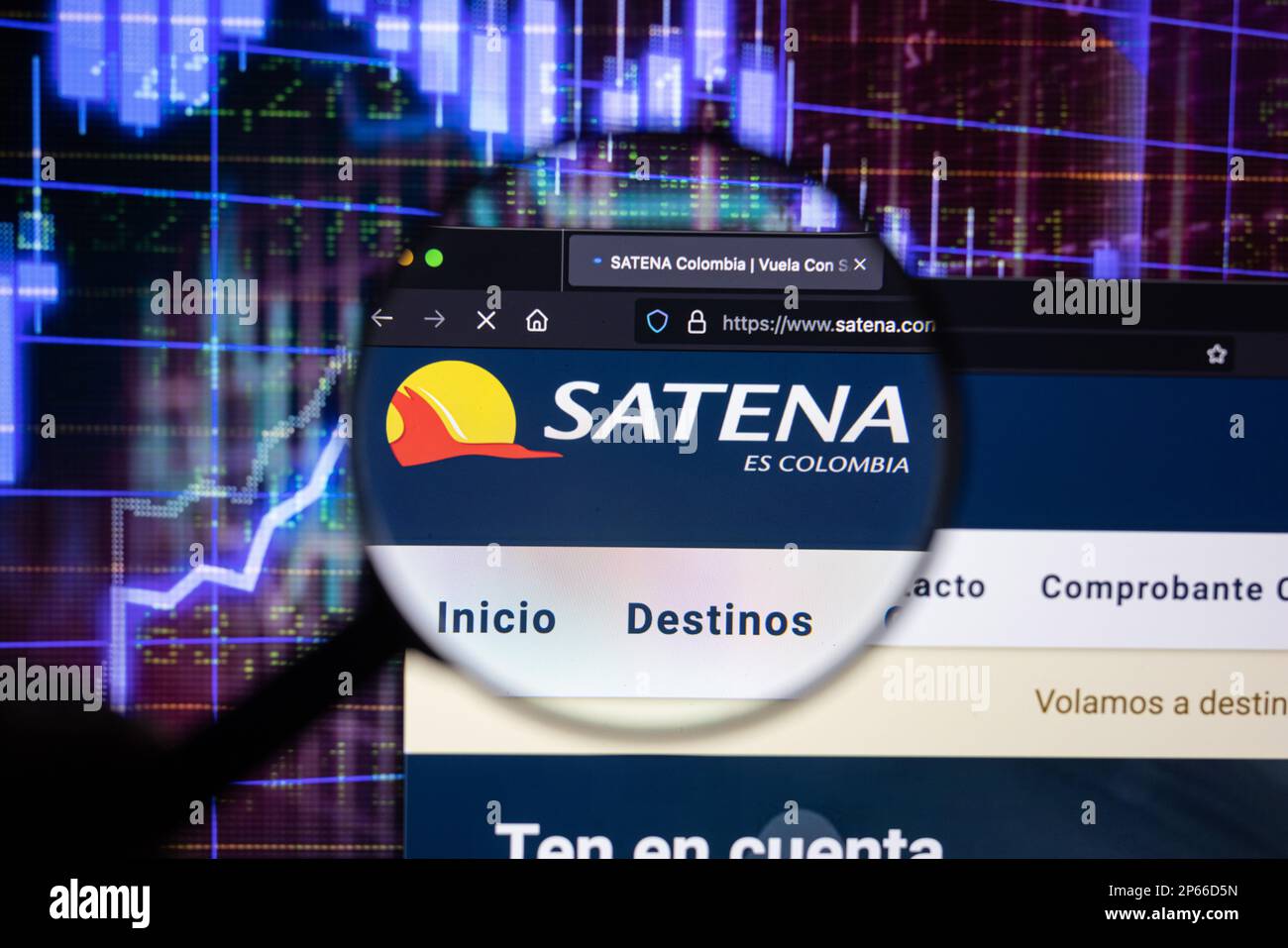 Le logo de la compagnie aérienne Satena sur un site Web avec des développements flous du marché boursier en arrière-plan, vu sur un écran d'ordinateur à travers une loupe Banque D'Images
