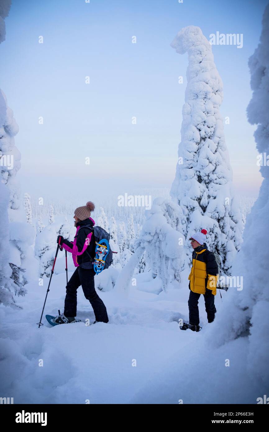 Mère gaie avec son raquette dans la forêt gelée, Parc national d'Oulanka, Ruka Kuusamo, Laponie, Finlande, Europe Banque D'Images