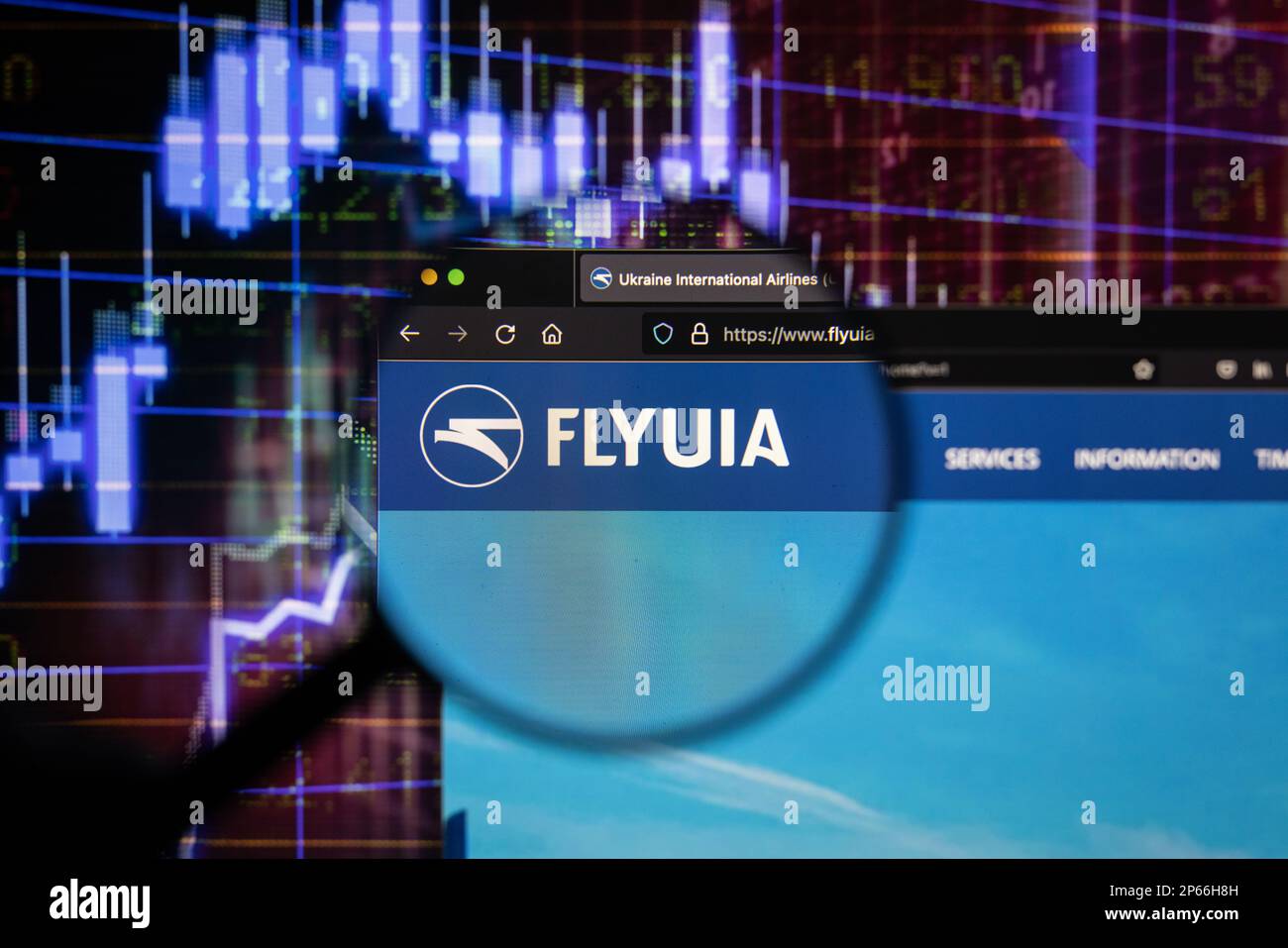 Flyuia compagnie aérienne logo sur un site avec des développements flous de marché boursier en arrière-plan, vu sur un écran d'ordinateur à travers une loupe Banque D'Images