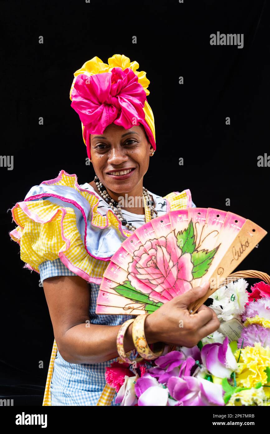 Fleur colorée fille avec la coiffure, ventilateur et panier, la Havane, Cuba, Antilles, Caraïbes, Amérique centrale Banque D'Images