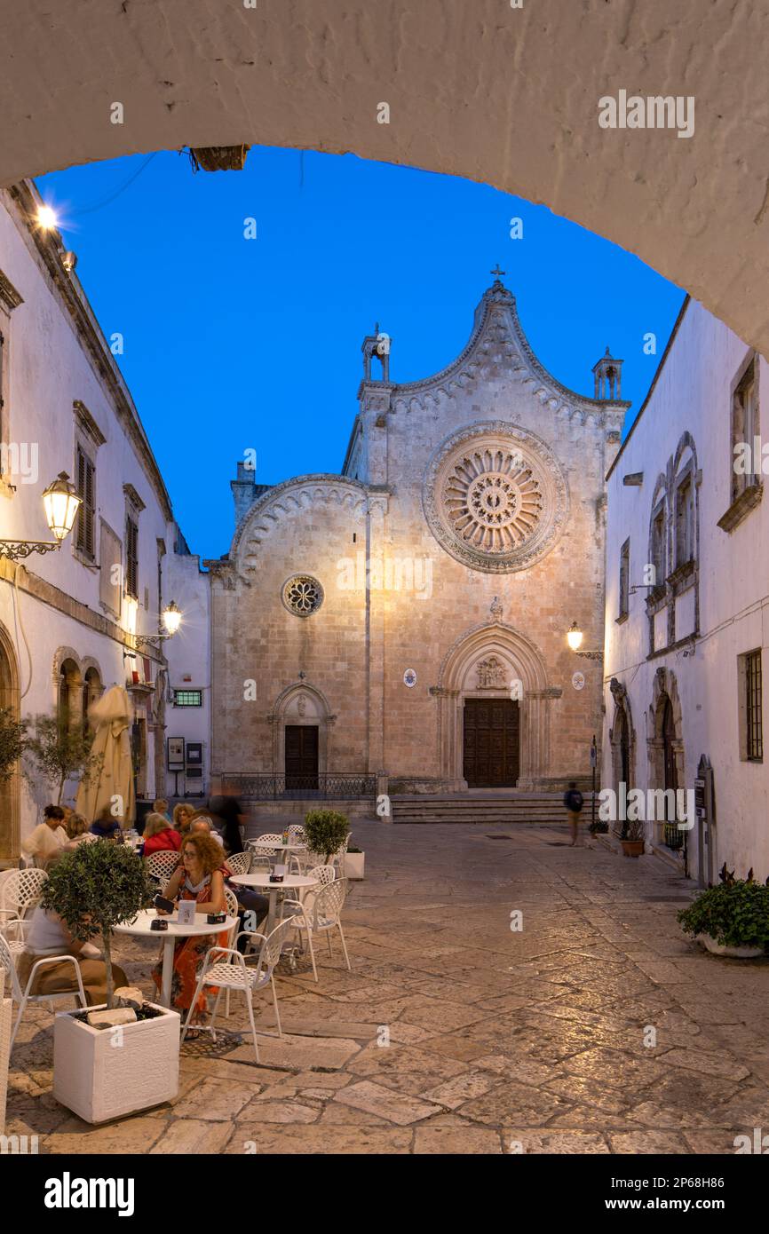 Cathédrale Santa Maria Assunta de la place Largo Arcid Teodoro Trinchera et café illuminés le soir, Ostuni, province de Brindisi Banque D'Images