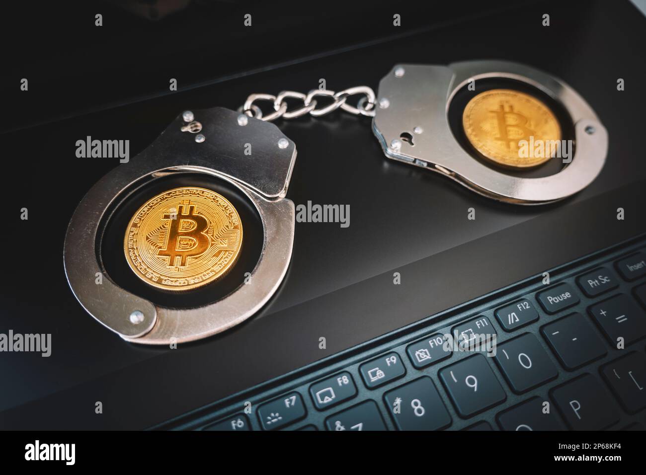 un bitcoin doré sur l'arrière-plan des menottes et un clavier noir pour ordinateur portable. Interdiction de la vente et de l'achat de bitcoins et de crypto-monnaies. Banque D'Images