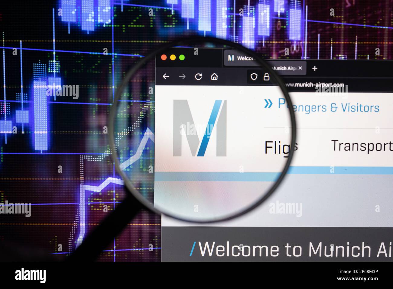 Logo de la société de l'aéroport de Munich sur un site web avec des développements flous du marché boursier en arrière-plan, vu sur un écran d'ordinateur à travers une loupe Banque D'Images