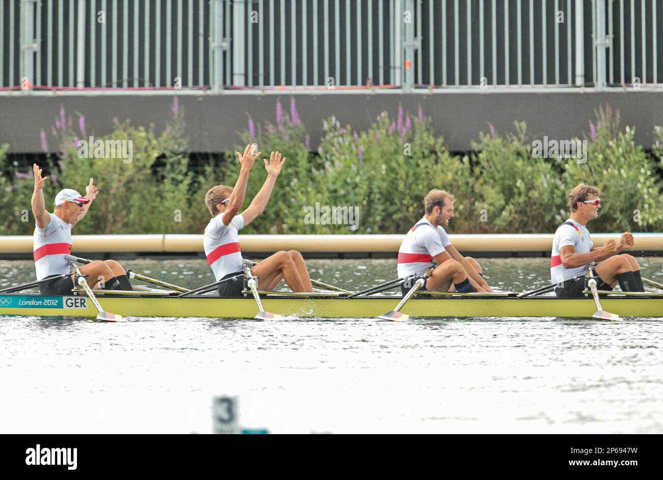 The German sculling team of Tim Grohmann, Lauritz Schoof, Phillipp Wende and Karl Schulze take a victory lap after winning a gold medal in the Men's Quadruple Sculls Rowing Competition at the London Olympics on Friday, August 3, 2012 in London, England (AP Photo/Margaret Bowles) Banque D'Images