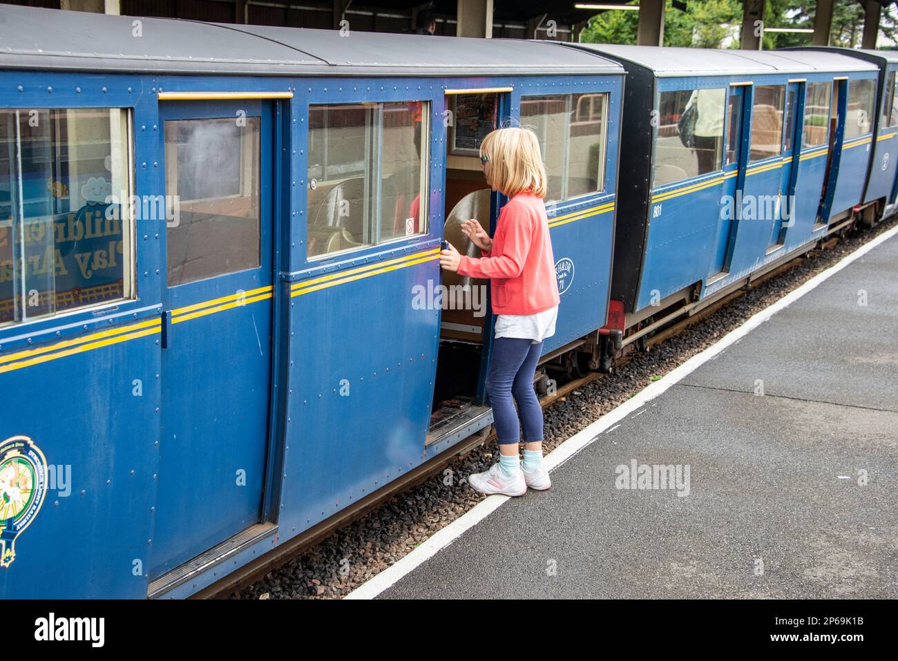 Une jeune fille à la gare de New Romney pour une promenade sur le train à vapeur miniature Romney, Hythe & Dymchurch (RH&DR) qui se déplace le long du 15 in Banque D'Images