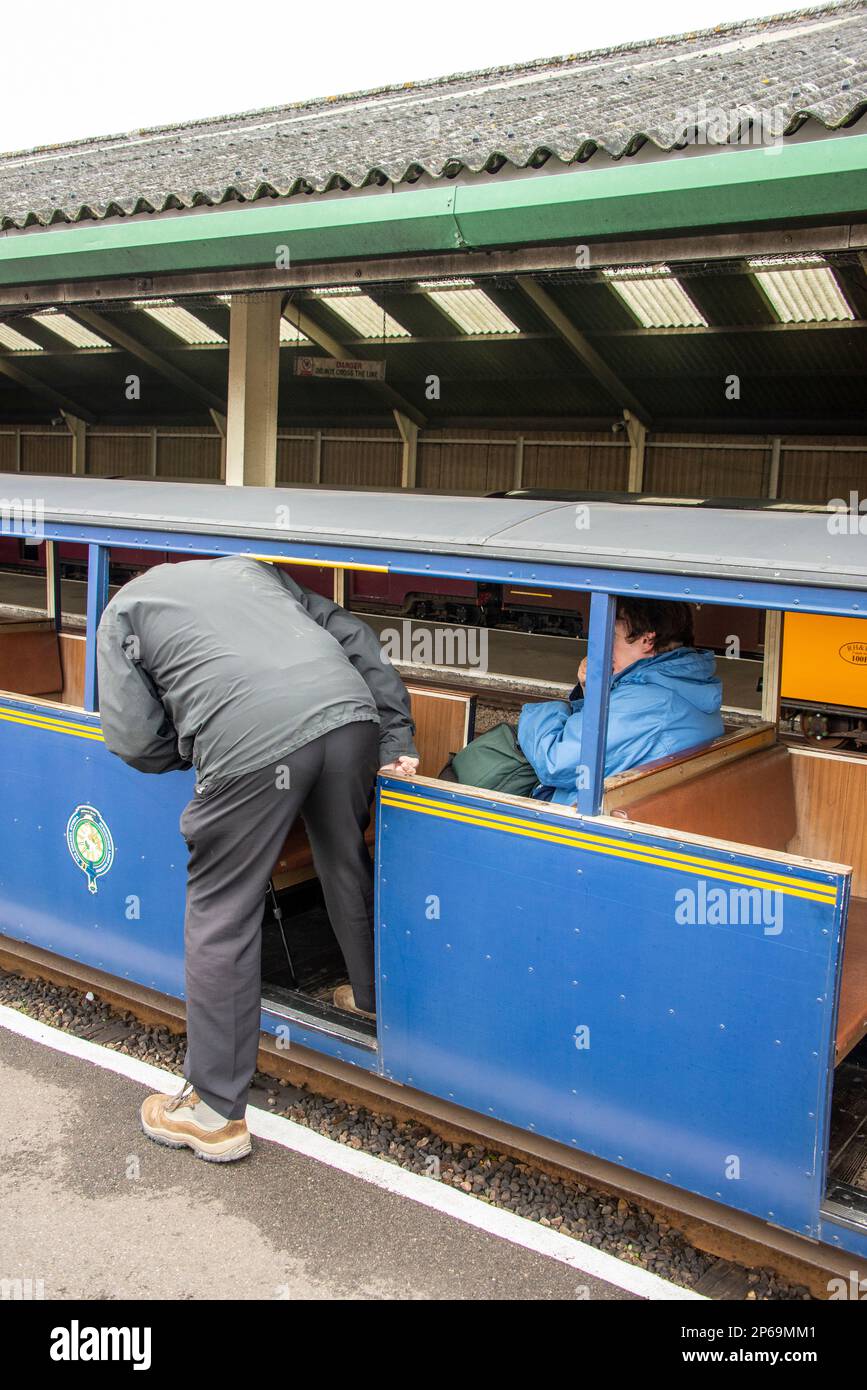 Un passager de train âgé et sa femme sont à bord d'une petite voiture à la gare de New Romney pour un trajet sur Romney, Hythe & Dymchurch (RH&DR Banque D'Images