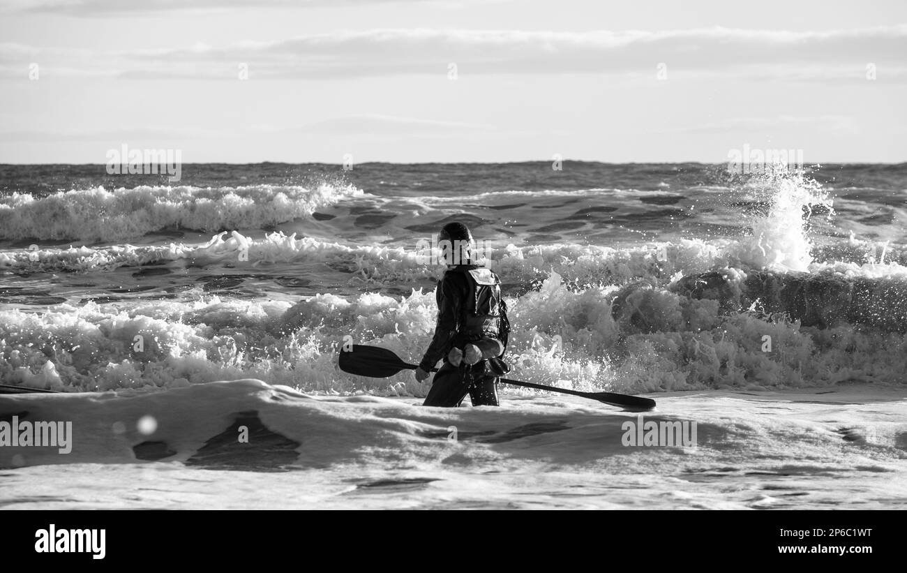 Kayakiste à la recherche de son kayak dans le surf après avoir chaviré Banque D'Images