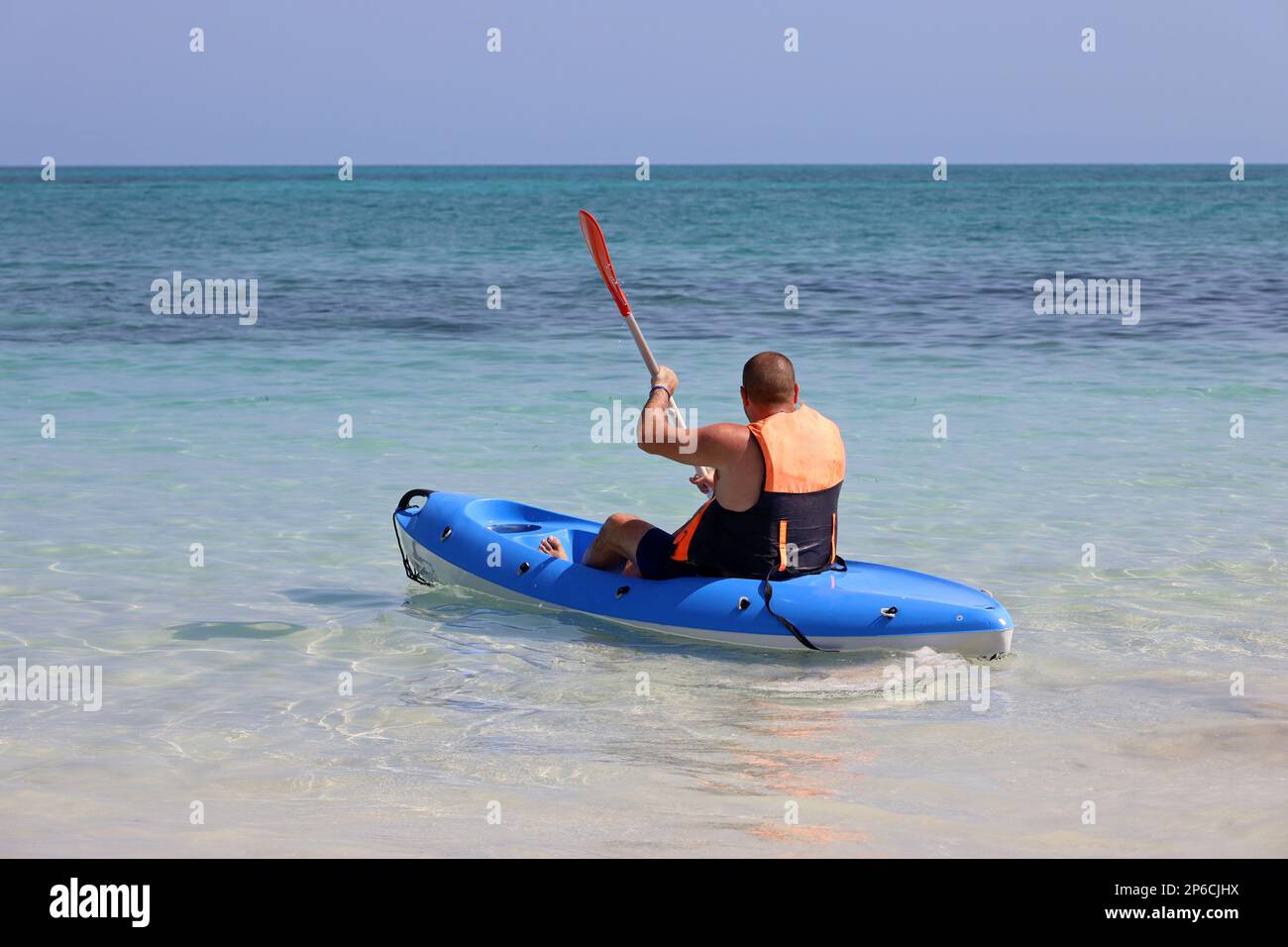Kayak dans la mer, homme portant gilet de sauvetage assis avec paddle en canoë. Concept de voyage et de sports nautiques Banque D'Images
