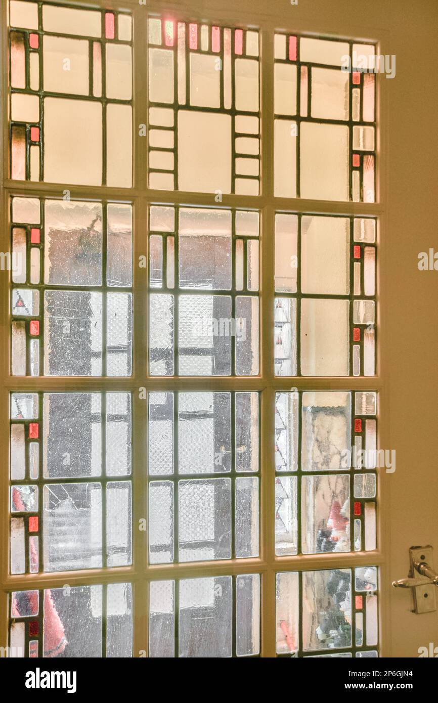 une fenêtre qui a été cassée et est en train d'être remplacée pour la faire ressembler à un vitrail Banque D'Images