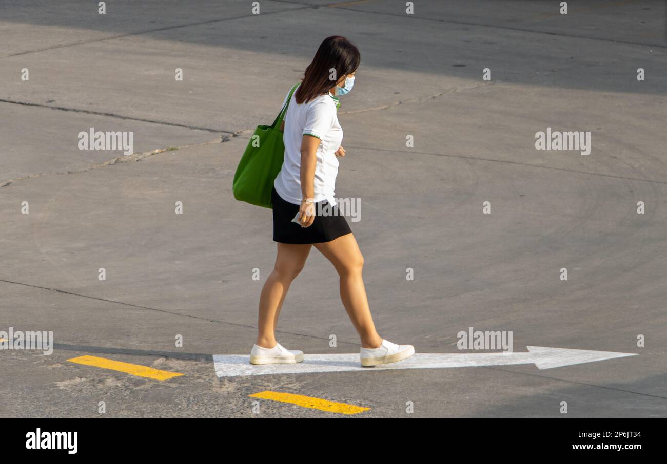 SAMUT PRAKAN, THAÏLANDE, 30 2023 JANVIER, Une femme dans la rue marche dans la direction de la flèche Banque D'Images
