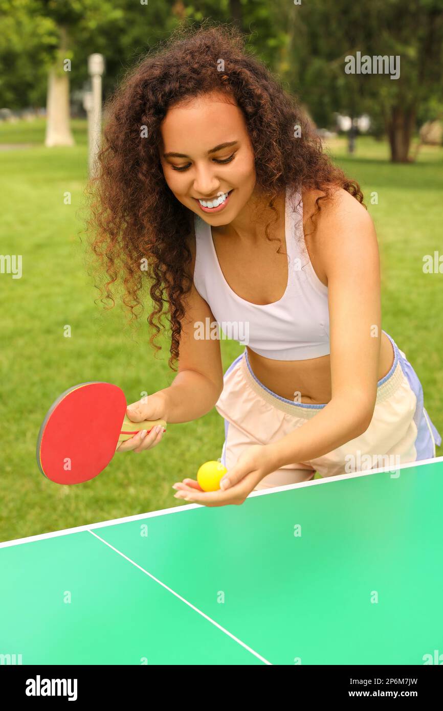 Jeune femme afro-américaine jouant au ping-pong en plein air Banque D'Images