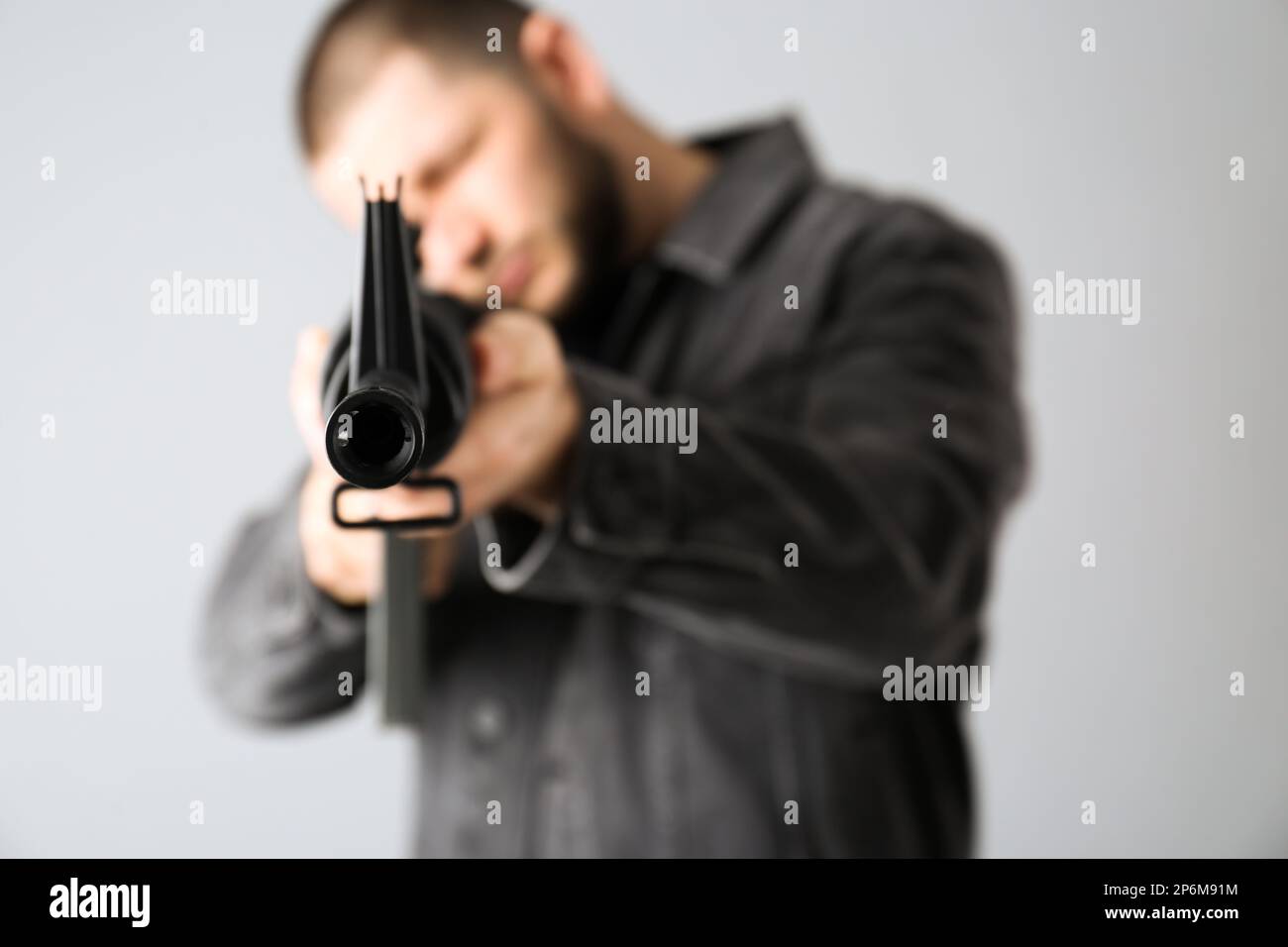 Fusil d'assaut. Homme visant le fusil sur fond clair, se concentrer sur le museau Banque D'Images