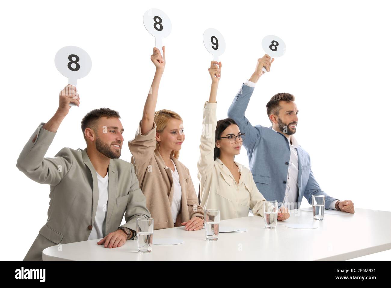 Panel de juges ayant différents signes de score à la table sur fond blanc Banque D'Images