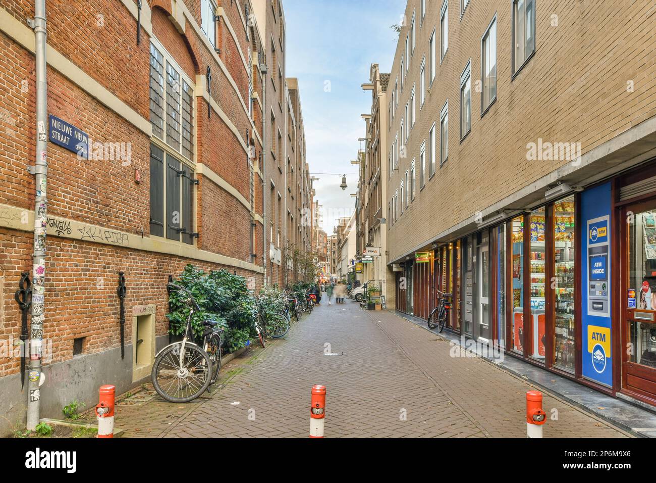 une rue de la ville avec des bâtiments en brique des deux côtés et des vélos garés dans les allées le long des pavés étroits Banque D'Images