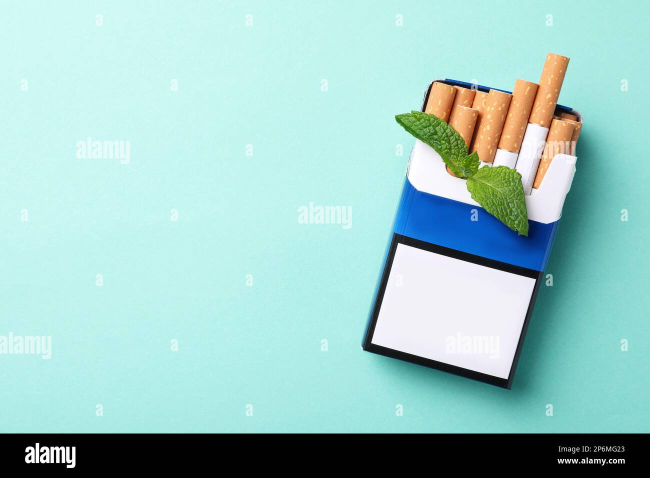 Paquet de cigarettes de menthol et de menthe sur fond turquoise, vue de dessus. Espace pour le texte Banque D'Images