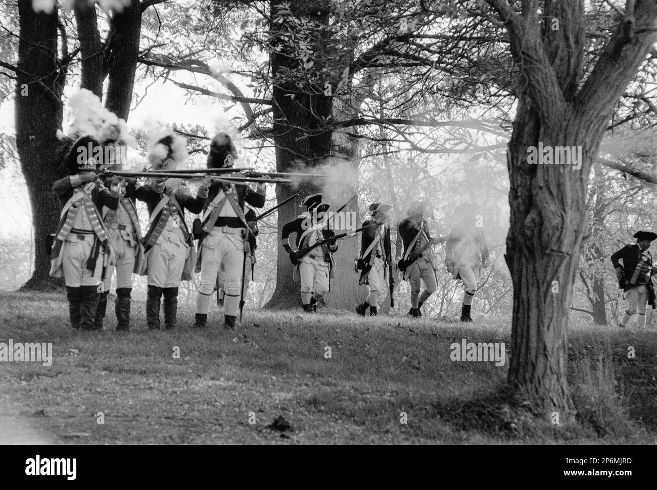 Red Coats tire leurs mousquets sur les colons en dessous d'eux lors d'une reconstitution de la guerre d'indépendance à la ferme Rebecca Nurse. Danvers, Massachusetts Banque D'Images