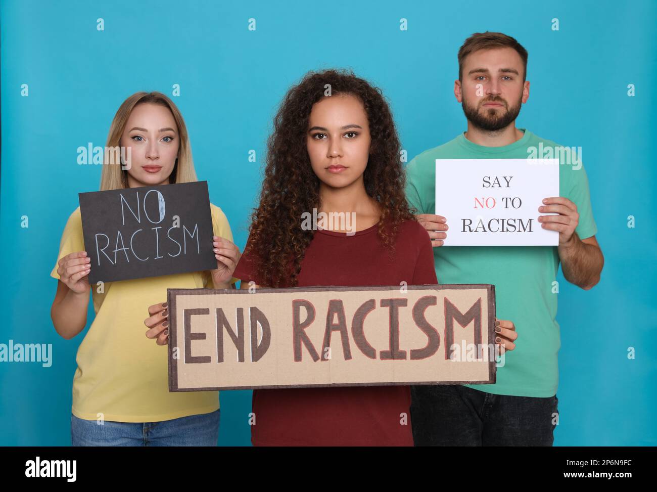 Groupe de personnes portant des affiches sur fond bleu clair. Concept de racisme Banque D'Images