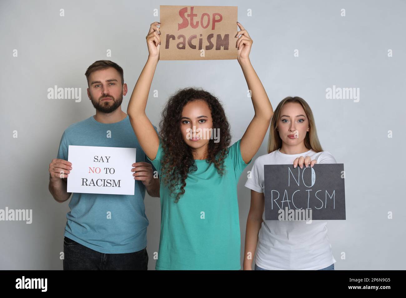 Groupe de personnes portant des affiches sur fond gris. Concept de racisme Banque D'Images