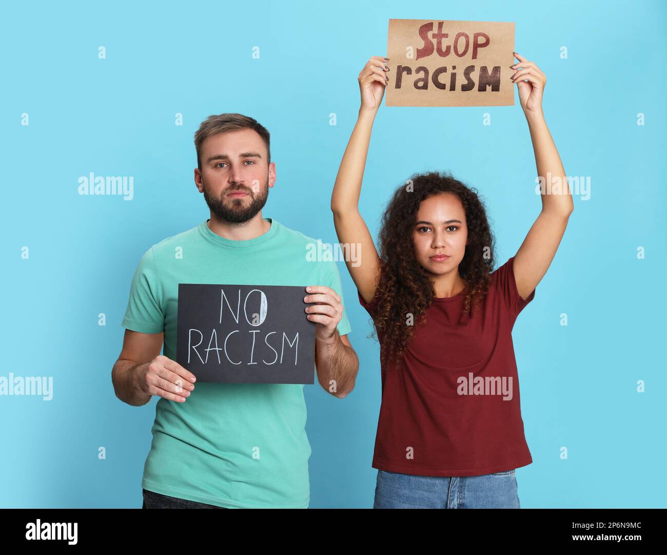 Jeune homme et femme afro-américaine portant des panneaux sur fond turquoise. Concept de racisme Banque D'Images