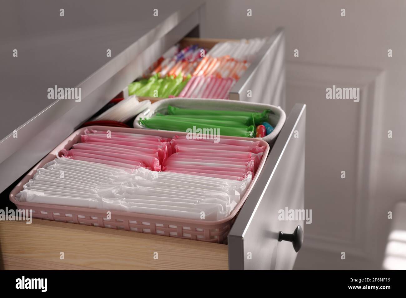 Ouvrez les tiroirs de l'armoire avec les tapis menstruels, les tampons et les pantyliners à l'intérieur, en gros plan Banque D'Images