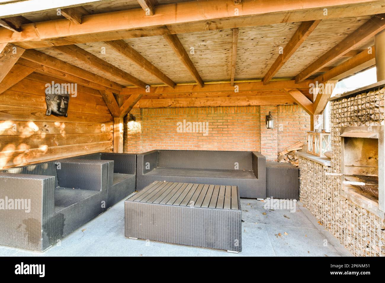 une cuisine extérieure avec des murs en briques et des poutres en bois au plafond, ainsi que des barbecues à utiliser Banque D'Images