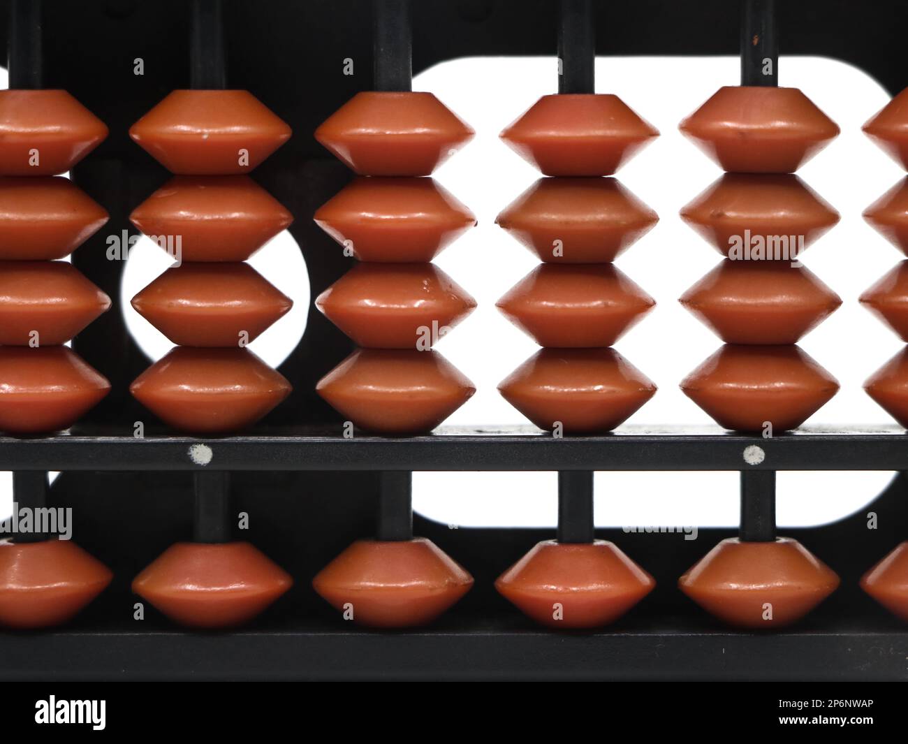 gros plan de perles brunes disposées sur les tiges d'un outil mathématique vintage abacus sur fond blanc Banque D'Images