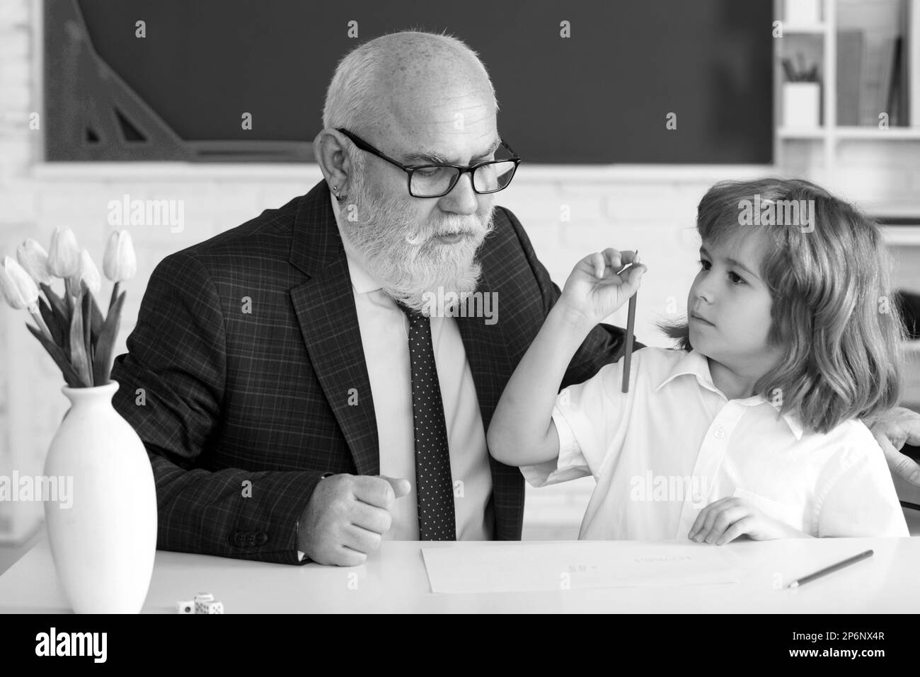 Concept de Teachering. Aide à apprendre. Ancien enseignant avec un élève en classe. Professeur d'école, éducation, enseignement. Leçon enfant élève. Banque D'Images