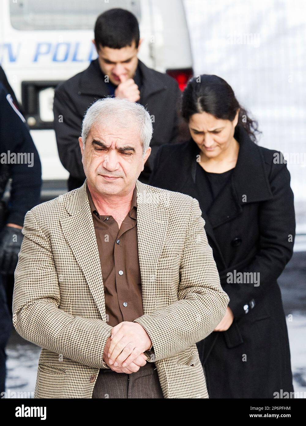 Mohammad Shafia, front, Tooba Yahya, center, and their son Hamed Shafia, back left, are escorted at the Frontenac County courthouse in Kingston, Ontario, Canada on Saturday, Jan. 28, 2012. The jury starts its first full day of deliberations to decide the fate of the three accused of killing four family members. Mohammad Shafia, 58, his wife Tooba Yahya, 42, and their son Hamed, 21, have pleaded not guilty to four counts each of first-degree murder. They're accused of killing Shafia sisters Zainab, 19, Sahar, 17, and Geeti, 13, as well as Rona Amir Mohammad, 52, their father's childless first w Banque D'Images
